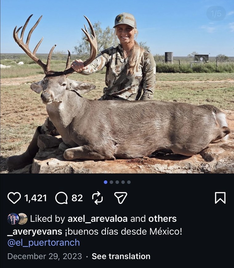Hunter posing with a mule deer buck at sunrise